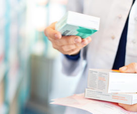 Pharmacist holding box of medications