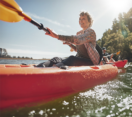 A middle-aged woman kayaking on the water
