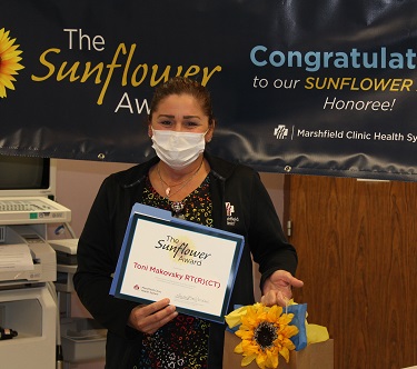 Computerized Tomography (CT) Technician Toni Makovsky holding Sunflower Award