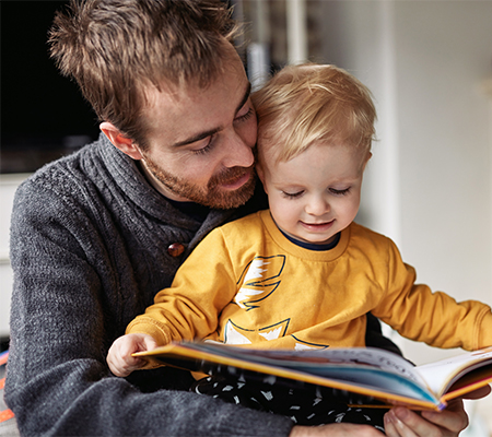 Dad reading to child, learning and helping with speech development
