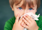 Child with virus blowing nose