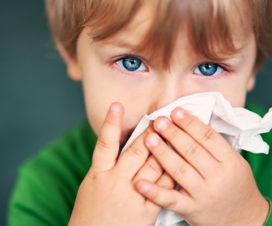 Child with virus blowing nose