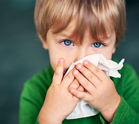 Child with virus blowing his nose