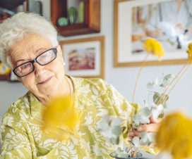 Elderly woman arranging flowers