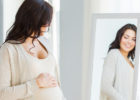 woman pregnant looking in mirror