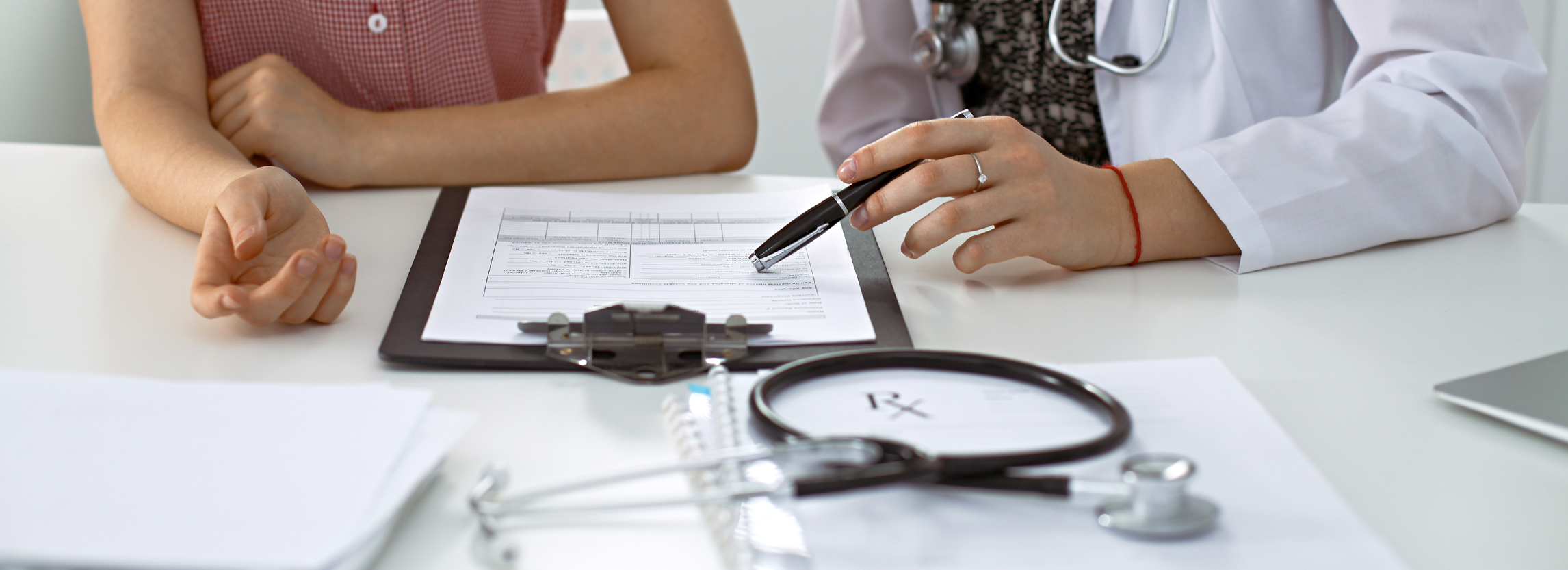 Photo of hands of a doctor and patient discussing lab results.