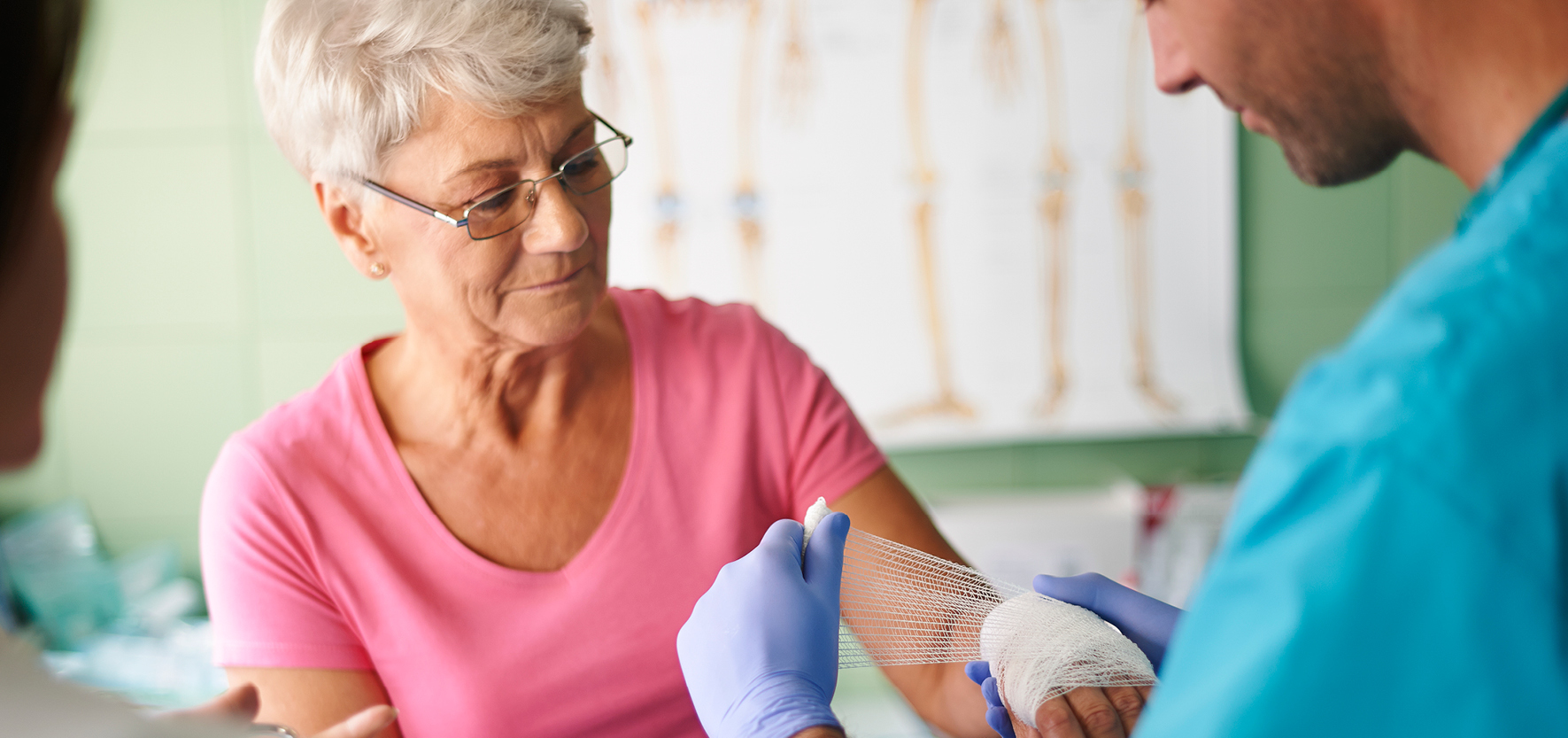 A woman getting her wound bandaged by a provider.