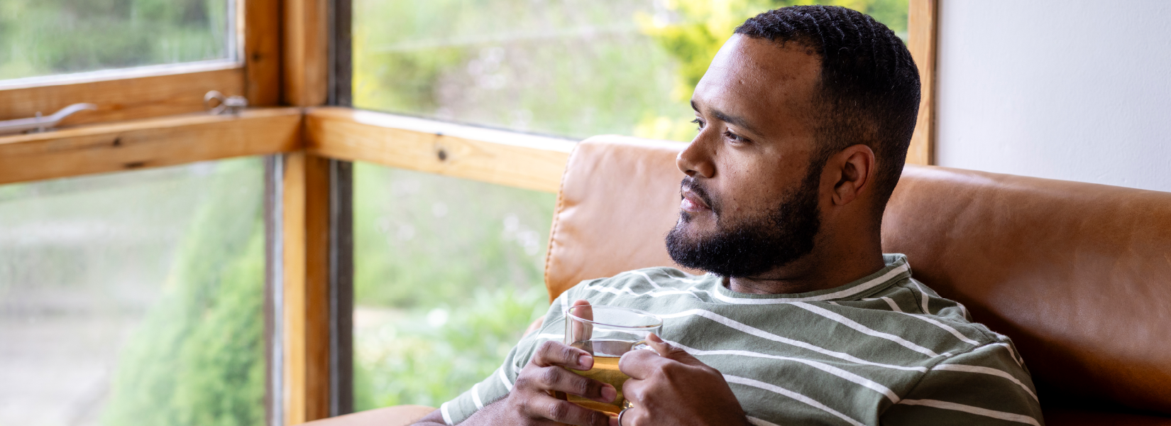 A depressed guy sitting and holding a coffee